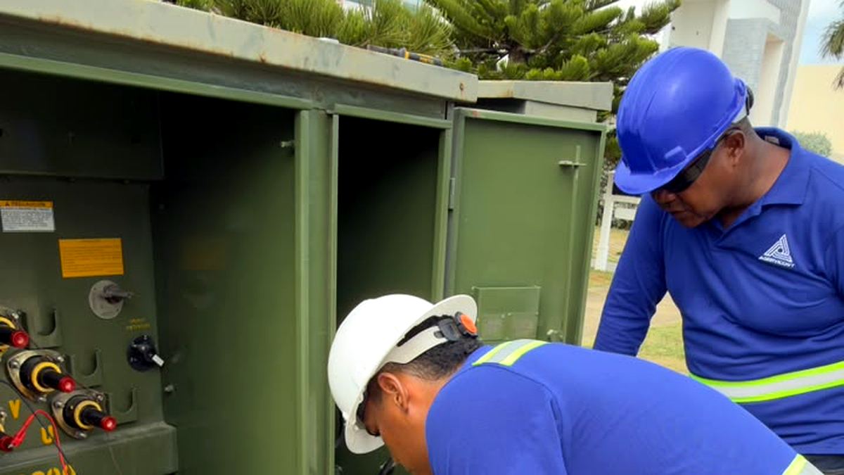 Dos técnicos revisando conexiones internas del transformador