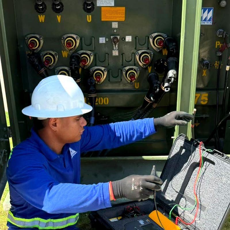Técnico con guante dieléctrico realizando prueba en tablero